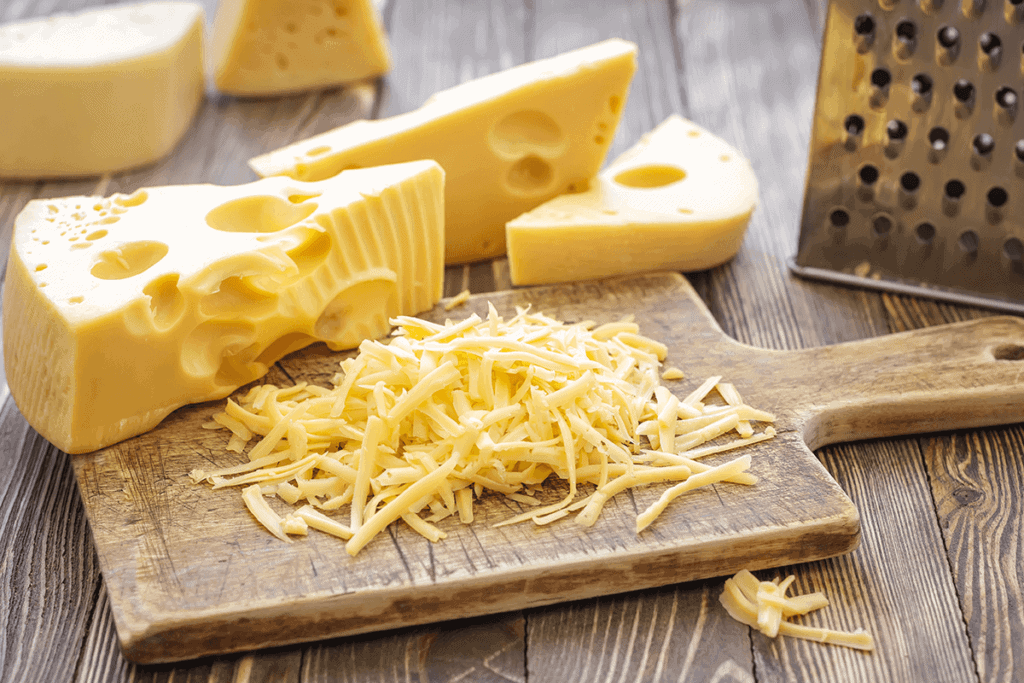 cheese on a cutting board with graded cheese