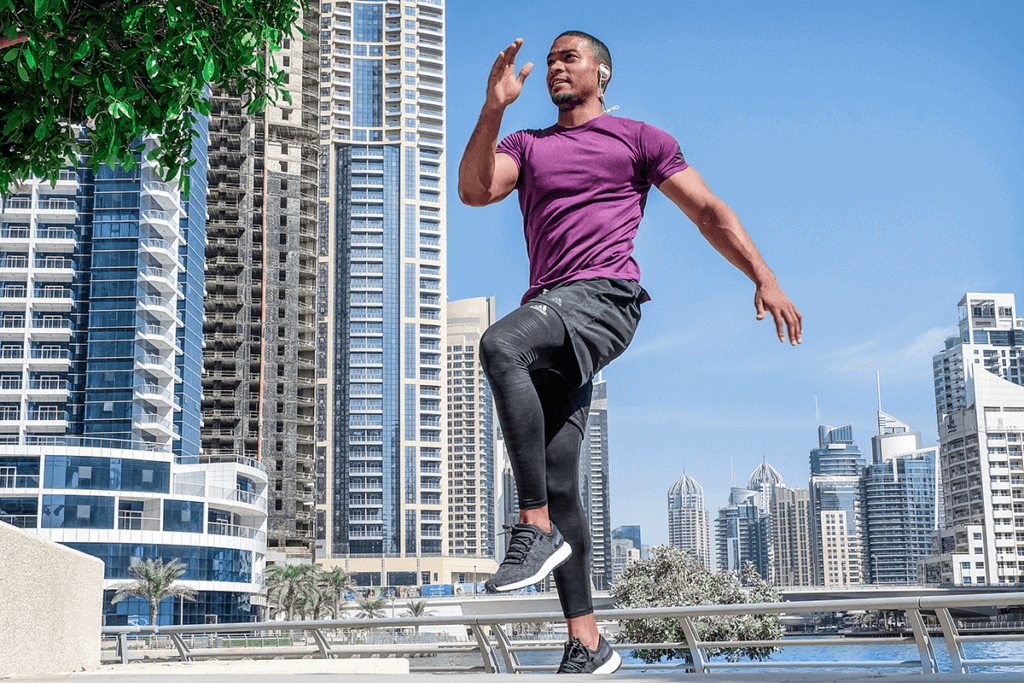 man exercising on the lake shore of a metropolitan with tall buildings in the background