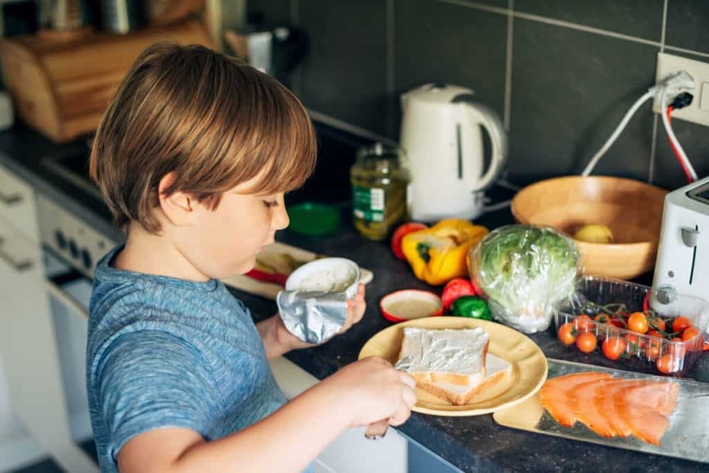 a boy making a sandwich in the kitchen