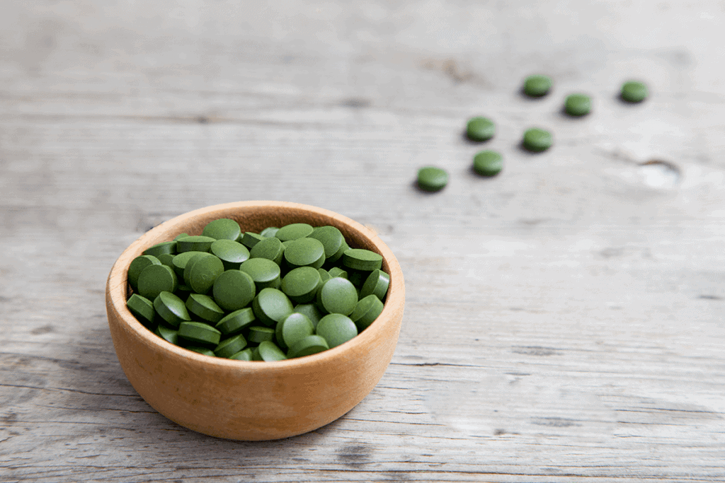Chlorella green tables next to plant and powder form