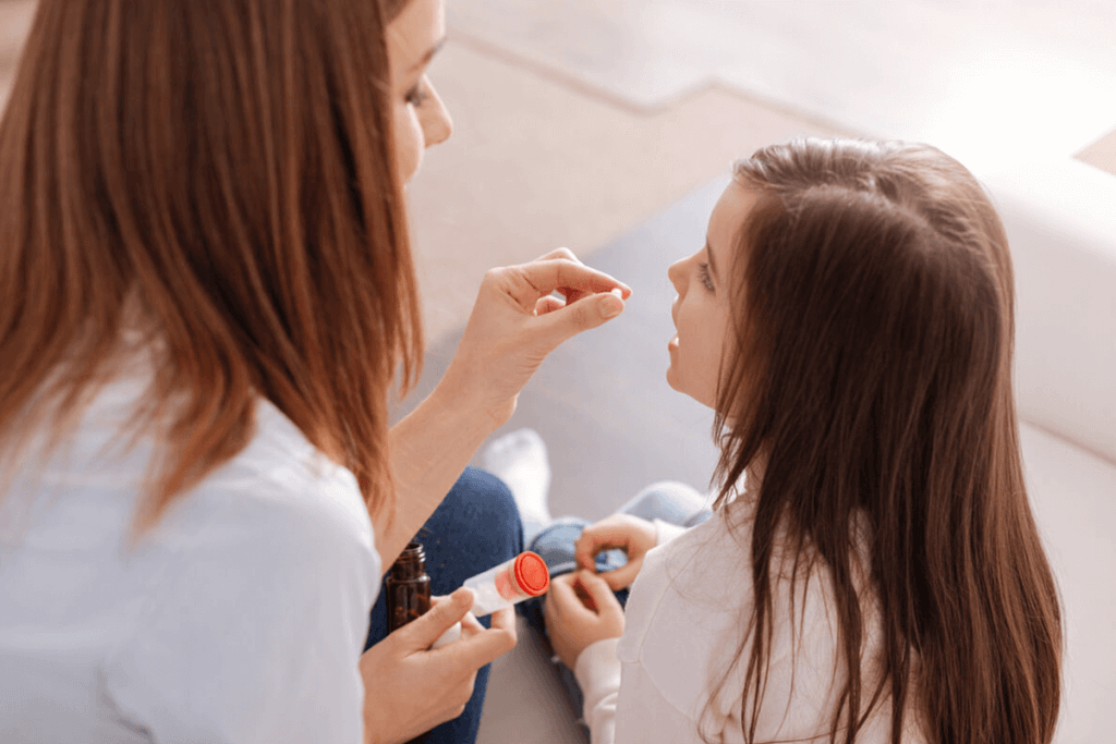 mother giving her child a supplement