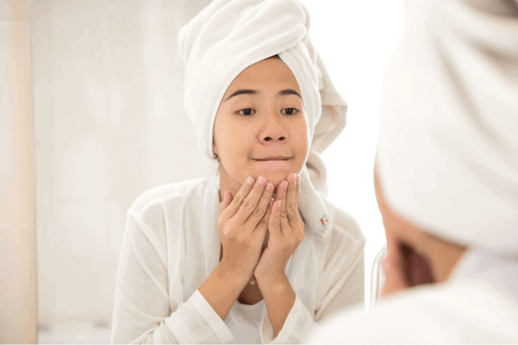 woman looking at her skin after shower