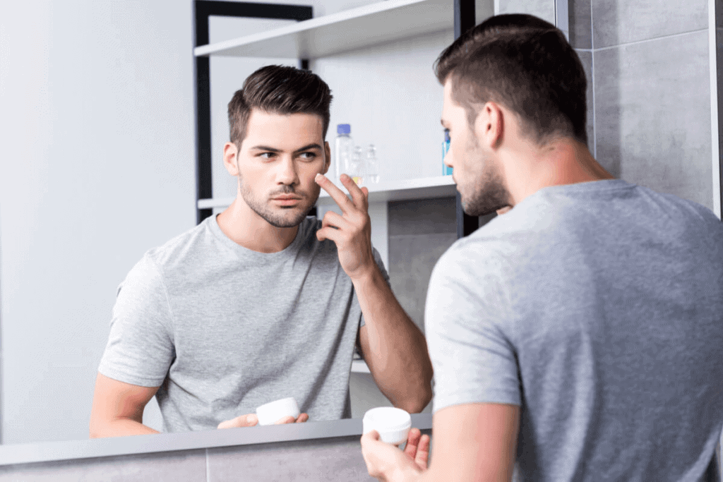 man putting cream on his face