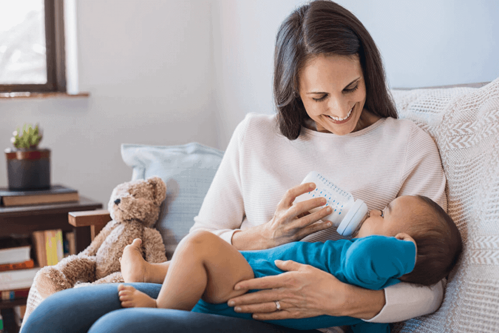 mother feeding a bottle of milk to her baby