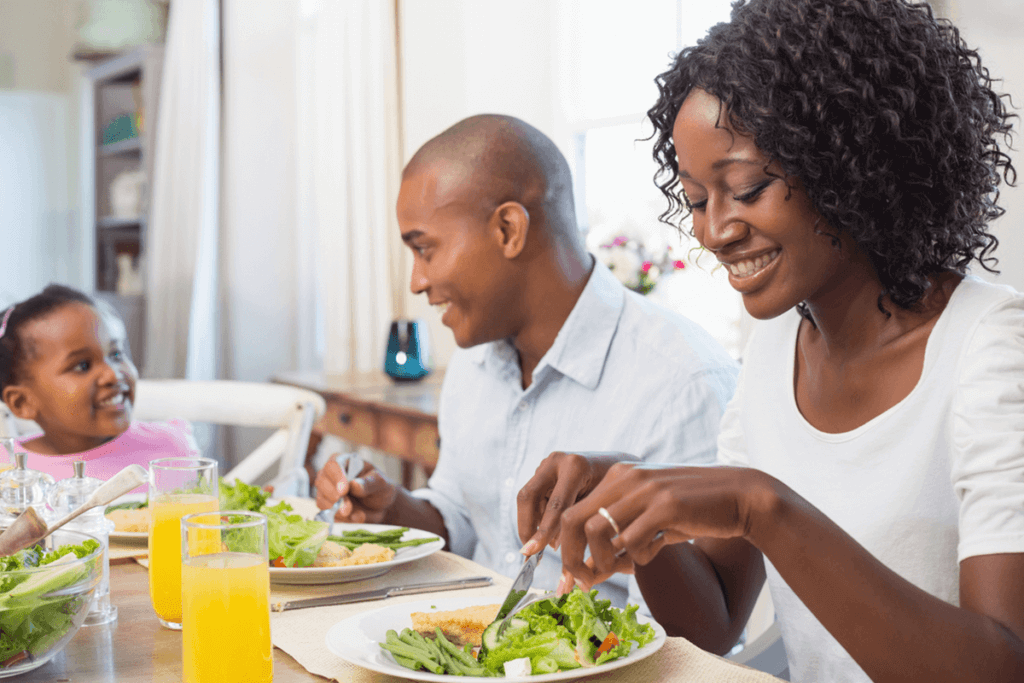 family of three sitting and eating food together