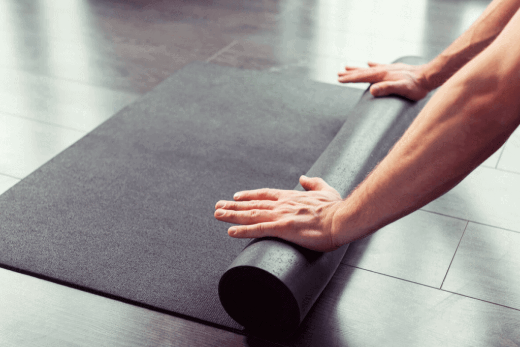 person rolling up yoga mat