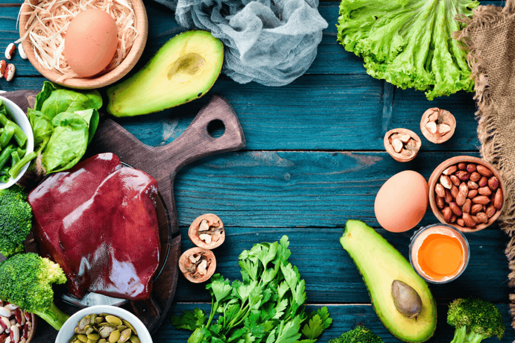Assortment of green vegetable and lentils on wooden table.