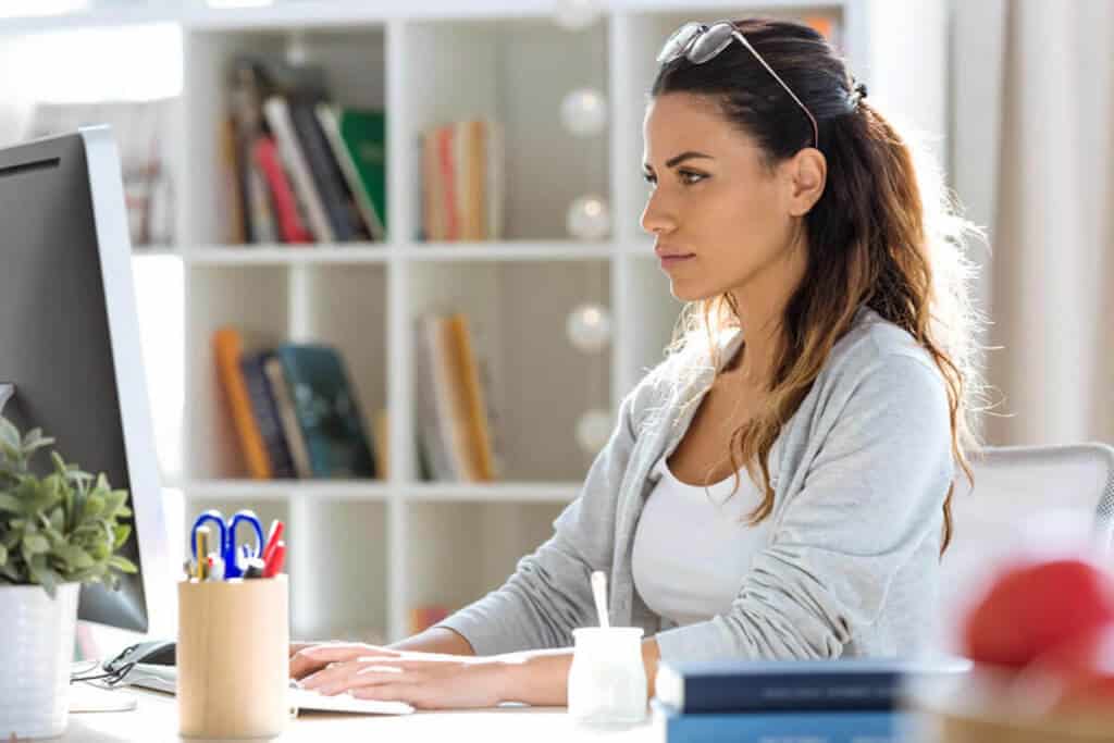 woman on her laptop focused with yogurt next to her