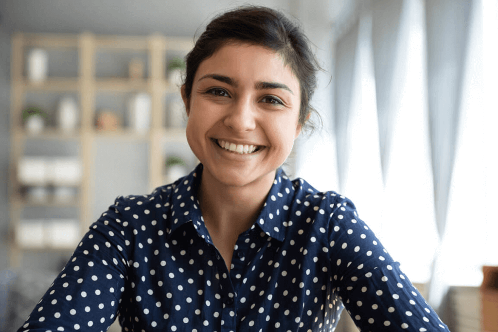 woman sitting in her house smiling at the camera