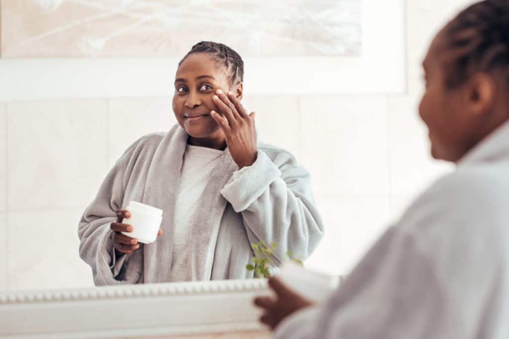 Woman applying topical honey on her face